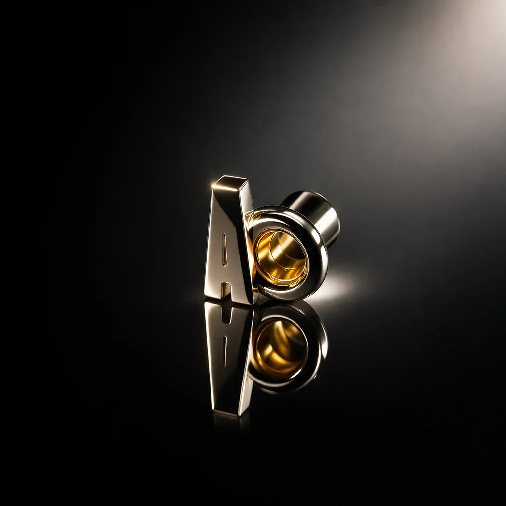 KORTONS polished gold metal eyelet and aglet detail with reflective surface on a dark background