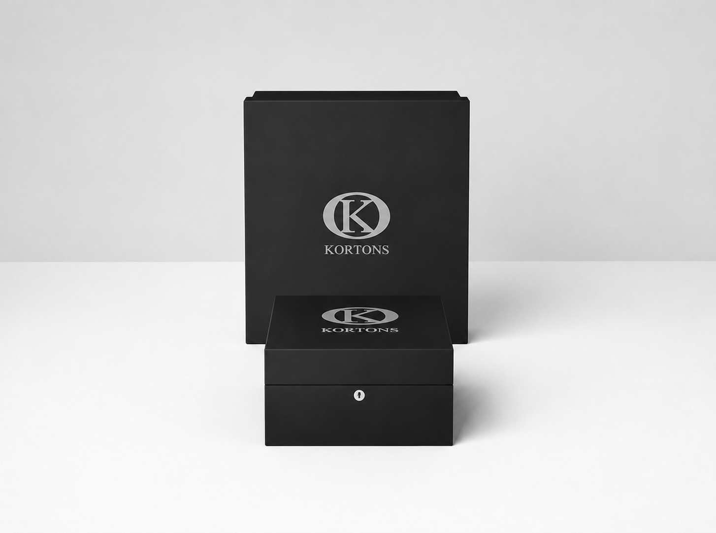 KORTONS luxury presentation box displayed before a matching signature packaging box on a clean light backdrop, featuring black semi-gloss finishes, refined proportions, and minimalist brand presentation.