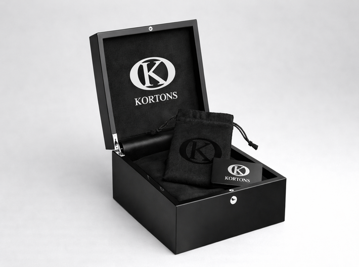 Open KORTONS luxury eyelet box with glossy black exterior and suede interior, featuring a black drawstring pouch and branded card inside, presented in a clean studio setting.